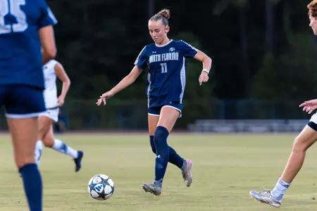 UNF Women's soccer player dribbles past defenders