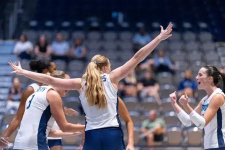 UNF Volleyball with arms in the air in celebration
