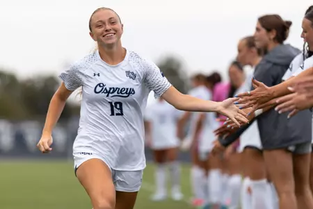 UNF Women's soccer player high fives teammates before match.