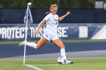 UNF Women's soccer player kicks the ball from a corner kick.