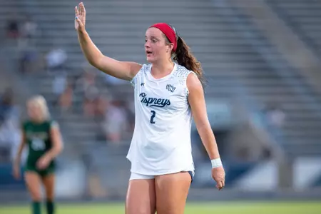 UNF Women's soccer player raises her hand.