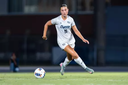 UNF Women's soccer player dribbles the ball.
