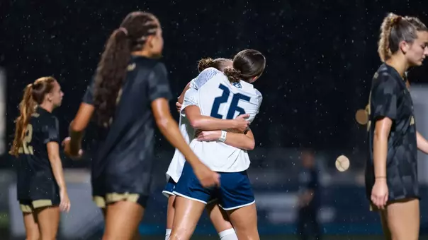 UNF Women's Soccer players hug in celebration after a goal scored
