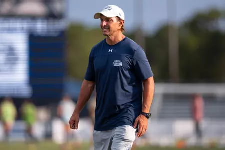 UNF Women's soccer assistant coach smiling before a match.