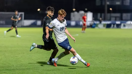 Midfielder Cameron Gray shields off an opposing player from the ball