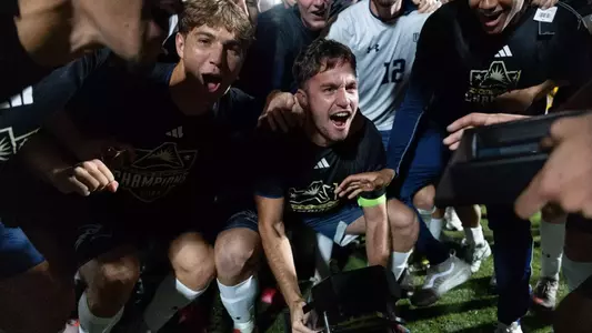 Midfielder Mark Romano celebrates with forward Luc Granitur and the rest of the team after the 2025 ASUN Tournament title