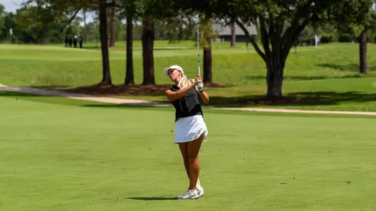 Kaitlyn Schroeder swings her club on a golf course