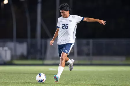 UNF men's soccer player kicks a ball