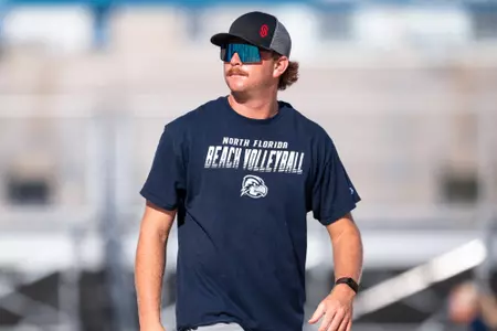 UNF volleyball assistant coach watching team practice