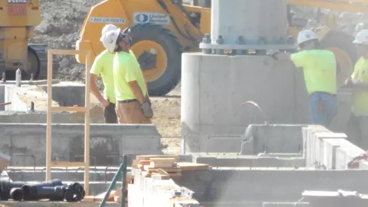 Workers line up the newest light tower at UNH's new Stadium. sixth and final
