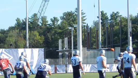 Sean Goldrich and the offense work out this week as steel rises behind them.