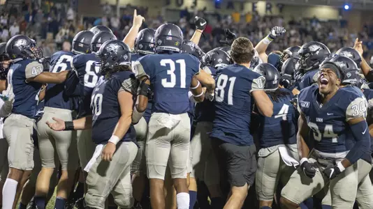 Nelson Thomas (34) and the Wildcats celebrate the winning field by Jason Hughes.