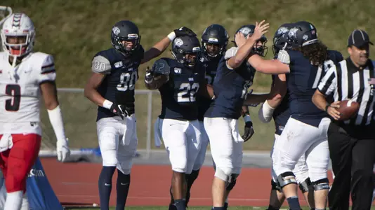 The Wildcats celebrate Evan Gray's (22) 72-yard dash to the end zone.