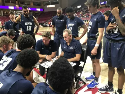 Coach Bill Herrion and the Wildcats discuss strategy during Tuesday night's game at BC.