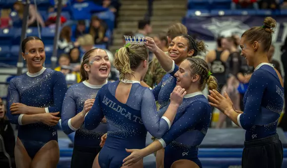 Team celebrating Mady Harvey after Beam routine