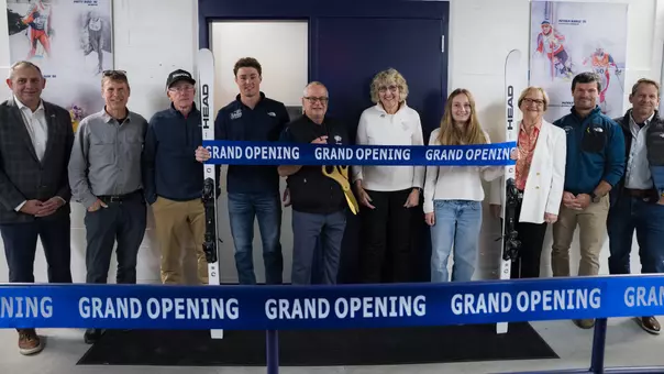Members of UNH Skiing and UNH Athletics stand before the renovated UNH SKIplex.