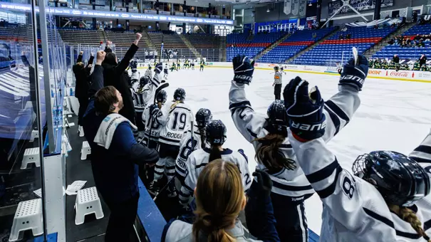 UNH women's hockey celebrates a goal from the bench.