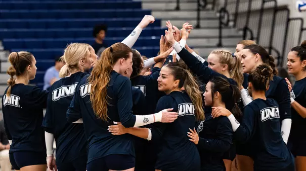 Photo of the volleyball team in a pregame huddle