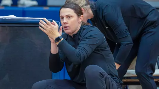 UNH women's basketball head coach Megan Shoniker coaching from the sidelines during the 2025-26 season.