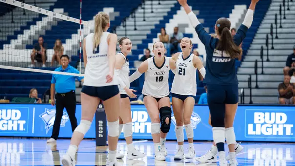 UNH volleyball team celebrates during a point