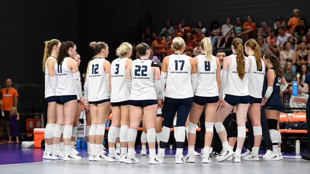 Volleyball team in a huddle during timeout.
