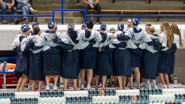 Swimming and Diving Team in group huddle before a 2025 meet at Swasey Pool