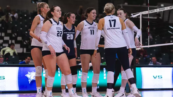 Volleyball huddles during a match against Dartmouth