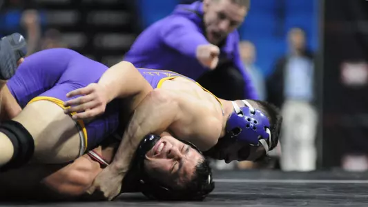 Bryce Steiert pins his opponent while coach Doug Schwab encourages from the side of the mat.