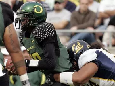 Quarterback Dennis Dixon is pulled down by California defender Mika Kane