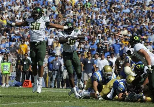 Oregon linebacker Kenny Rowe, left, and