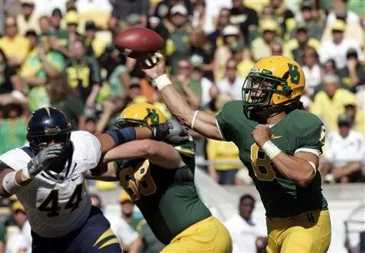 Quarterback Jeremiah Masoli, right, throws downfield vs. Cal.
