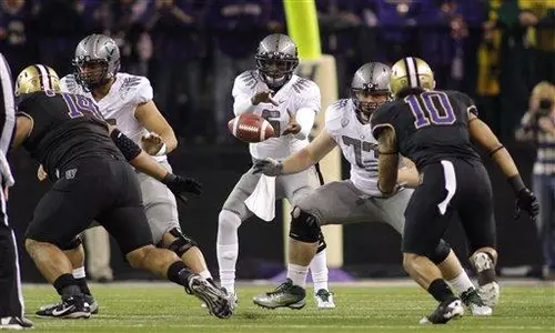 Darron Thomas (5) takes a snap as Carson York (77) blocks a Washington defender