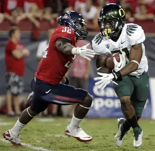 LaMichael James (21) eludes Arizona's Lyle Brown (32)