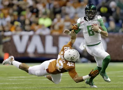 Oregon's Marcus Mariota (8) is pulled