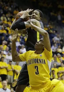 Oregon center Tony Woods, top, grabs a
