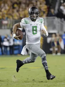 Oregon quarterback Marcus Mariota runs