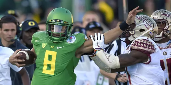 Marcus Mariota, left, pushes away Florida State safety Tyler Hunter