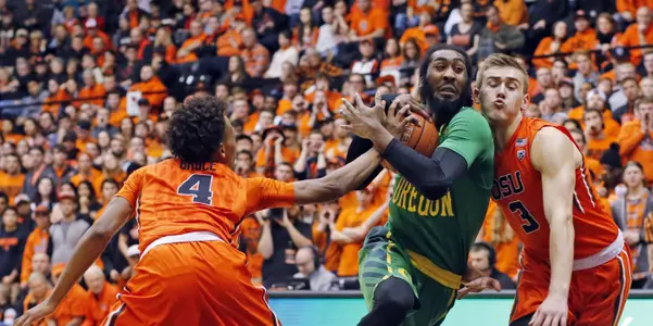 Oregon's Dwanye Benjamin, center, drives