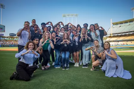 Oregon student-athletes pose for a photo while throwing their O's