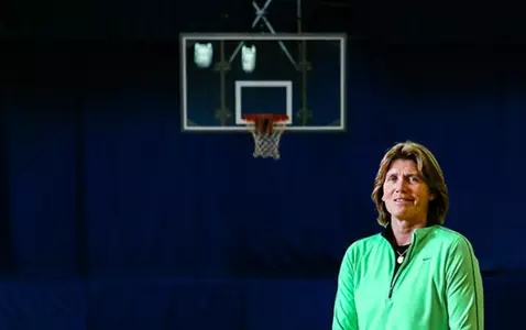 Bev Smith poses for a photoshoot on a basketball court
