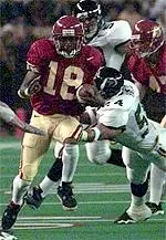 R. Jay Soward rushes<br>through the Rainbow defense<br>in the Trojans victory.