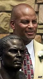 Former USC and San Francisco 49ers great Ronie Lott poses with his bronze bust after enshrinement into the Pro Football Hall of Fame Saturday, July 29, 2000, in Canton, Ohio.