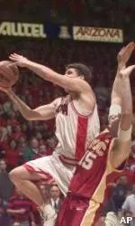 Kostas Charissis defends against Arizona's Luke Walton as he drives to the basket in the first half.