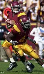 Carson Palmer threw for 348 yards and four TDs as USC rolled past UW.