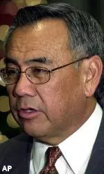Norm Chow, offensive coordinator for the Southern California football team and winner of the 2002 Broyles Award, speaks with a reporter during a reception before the award ceremony. The Broyles Award is given annually to the nation's top assistant coach.