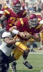 Matt Leinart is tackled by Hawaii's Houston Ala in the first half.