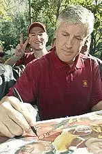 USC head coach Pete Carroll signs a newspaper tear sheet displaying the Trojans team members for a fan following the presentation of the Associated Press national college football trophy on the Los Angeles campus Monday.