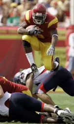 Reggie Bush (5) hurdles over a cluster of players while rushing for five yards against Arizona during the second quarter. (AP Photo/Danny Moloshok)
