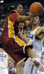 USC's Derrick Craven puts up an off-balance shot while being guarded by UCLA's Ryan Hollins during the second half. (AP Photo/Chris Pizzello)