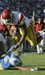C. J. Cable dives into the end zone as wide receiver Steve Smith blocks UCLA's linebacker John Hale during the second quarter. (AP Photo/Chris Carlson)